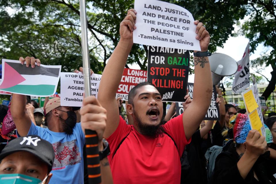 Filipino activists shout slogans as they are blocked by police while trying to march in front of the Israel embassy in Taguig, Philippines (AP)