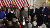 Charles and Gladys Sicknick, father and mother of slain U.S. Capitol Police Officer Brian Sicknick, are greeted by Senate Majority Leader Chuck Schumer of N.Y., center, with Senate Minority Leader Mitch McConnell of Ky., and House Minority Leader Kevin McCarthy of Calif., at right, during a Congressional Gold Medal ceremony honoring law enforcement officers who defended the U.S. Capitol on Jan. 6, 2021, in the U.S. Capitol Rotunda in Washington, Tuesday, Dec. 6, 2022. The members of the Sicknick family declined to shake hands with McConnell and McCarthy. At left is U.S. Capitol Police Chief Thomas Manger and House Speaker Nancy Pelosi of Calif. (AP Photo/Carolyn Kaster)