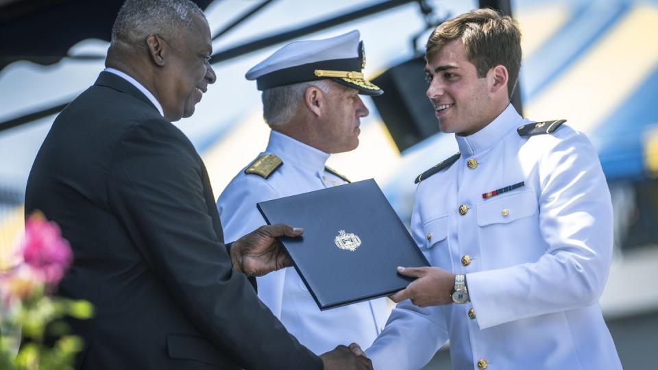 Secretary of Defense Lloyd J. Austin III awards a diploma at the U.S. Naval Academy's Class of 2023 graduation ceremony in Annapolis, Md. (Chad J. McNeeley/DoD)