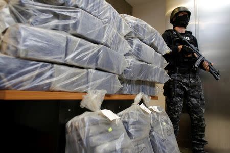 A Romanian special forces unit member stands guard near bags containing part of 2.5 tonnes of cocaine seized in the Black Sea port of Constanta. Inquam Photos/Octav Ganea/via REUTERS