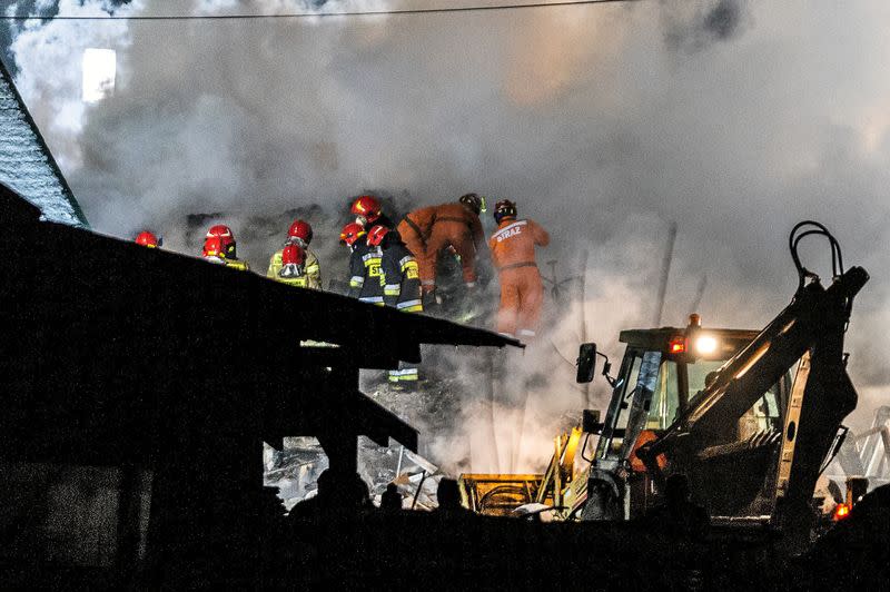 Firefighters work at the site of a building levelled by a gas explosion in Szczyrk,