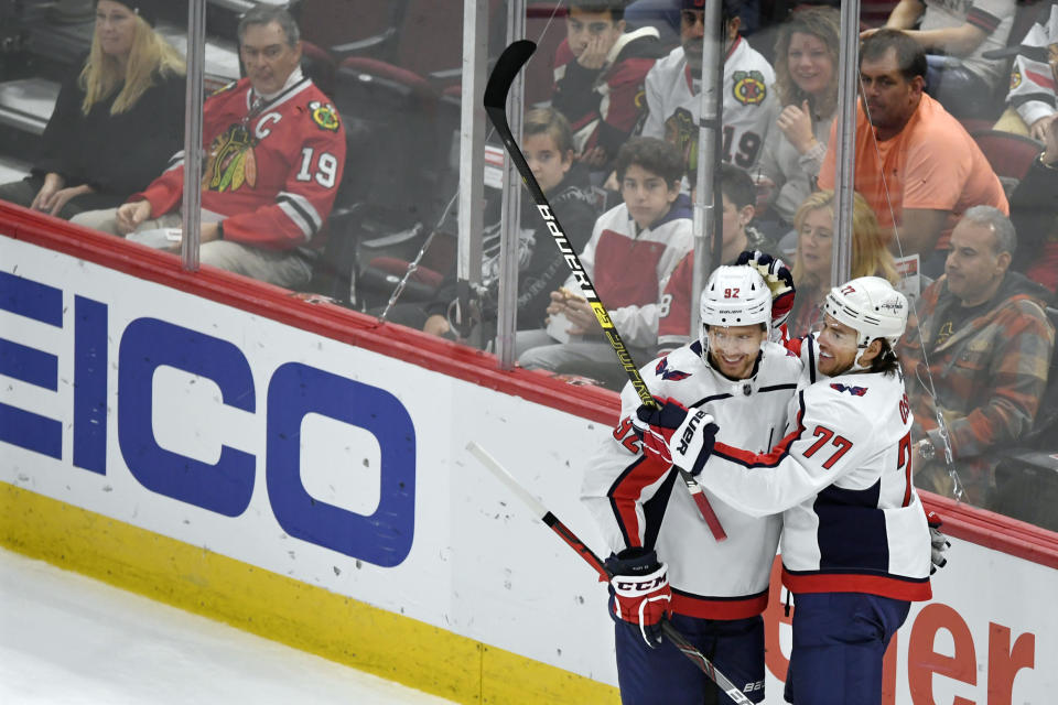 Washington Capitals' T.J. Oshie (77) celebrates with teammate Evgeny Kuznetsov (92), of Russia, after scoring a goal during the first period of an NHL hockey game against the Chicago Blackhawks, Sunday, Oct. 20, 2019, in Chicago. (AP Photo/Paul Beaty)