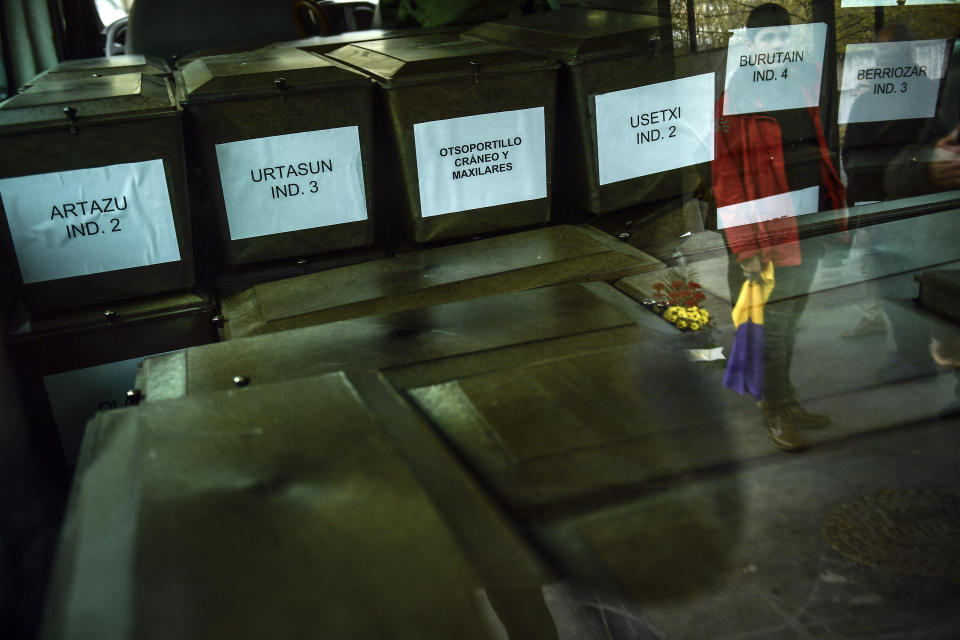 A Spanish Republican flag, right, reflected in the window of a vehicle carrying coffins, some of 46 unidentified people killed during the Spanish Civil War, in Pamplona, northern Spain, Monday, April 1, 2019. Marking eight decades since the end of the Spanish Civil War, the remains of 46 unidentified victims of the conflict have been reburied in the northern city of Pamplona. More than half a million people died in the 1936-1939 war between rebel nationalist forces led by Gen. Francisco Franco and defenders of the short-lived Spanish republic. (AP Photo/Alvaro Barrientos)