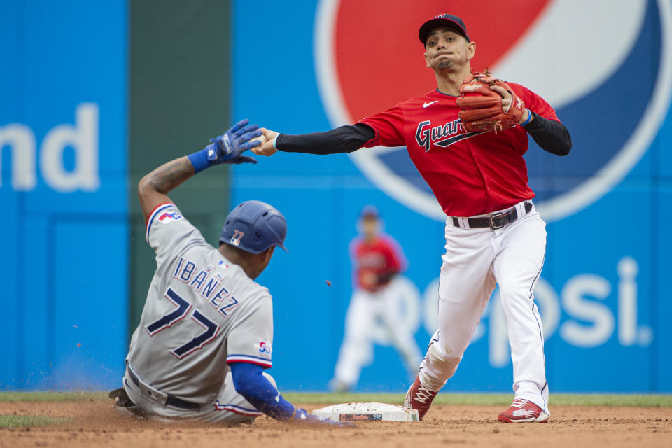 Cleveland Guardians' Andres Gimenez forces Texas Rangers' Andy Ibanez at second but can't complete a double play during the fifth inning of the first game of a baseball doubleheader in Cleveland, Tuesday, June 7, 2022. (AP Photo/Phil Long)