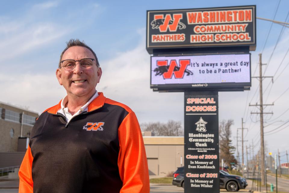 Washington Community High School athletic director Herb Knoblauch stands near the school's marquee where the name of his son Evan, who was killed in a car accident in 2008, is honored. Knoblauch is retiring after this school year after three decades in education and athletics.