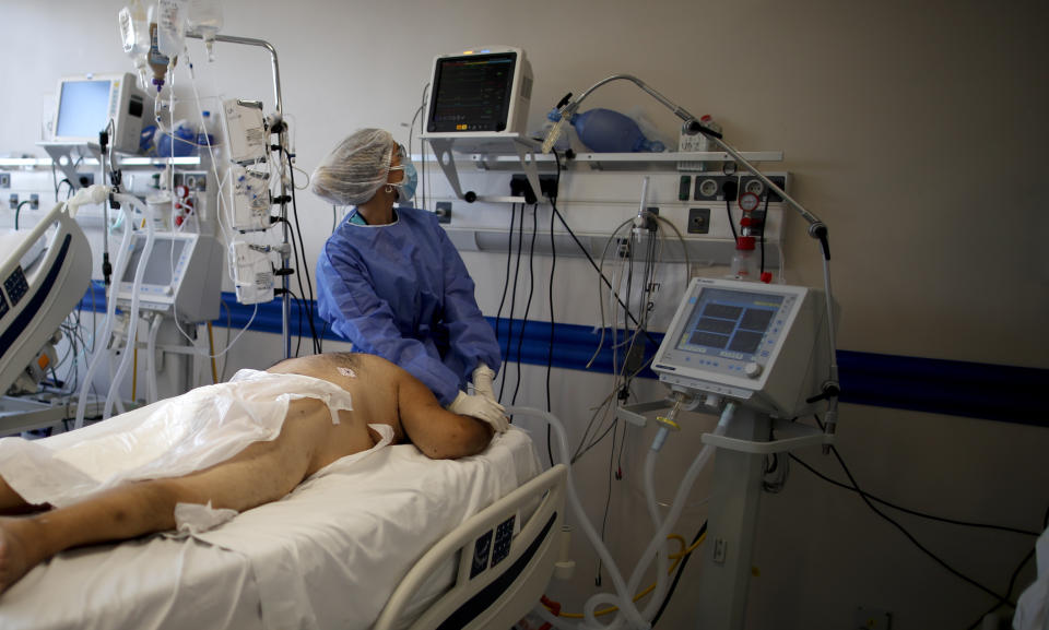 Un trabajador de la salud atiende a un paciente con COVID-19 en el hospital Dr. Norberto Raúl Piacentini, en Lomas de Zamora, Argentina, el viernes 23 de abril de 2021, en medio de la pandemia de coronavirus. (AP Foto/Natacha Pisarenko)