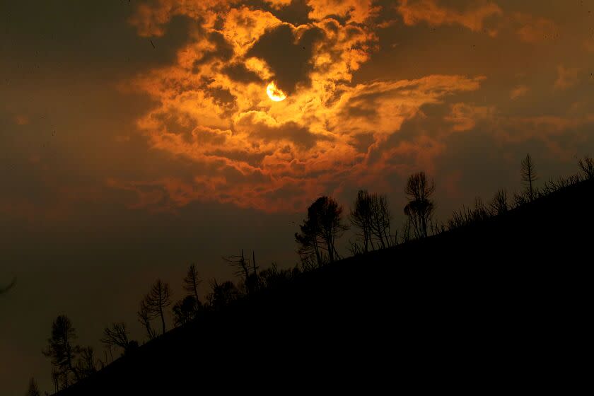 MARIPOSA, CALIF. - JULY 26, 2022. The sun sets behind a ridge charred by the Oak fire near Mariposa on Tuesday, July 26, 2022. (Luis Sinco / Los Angeles Times)