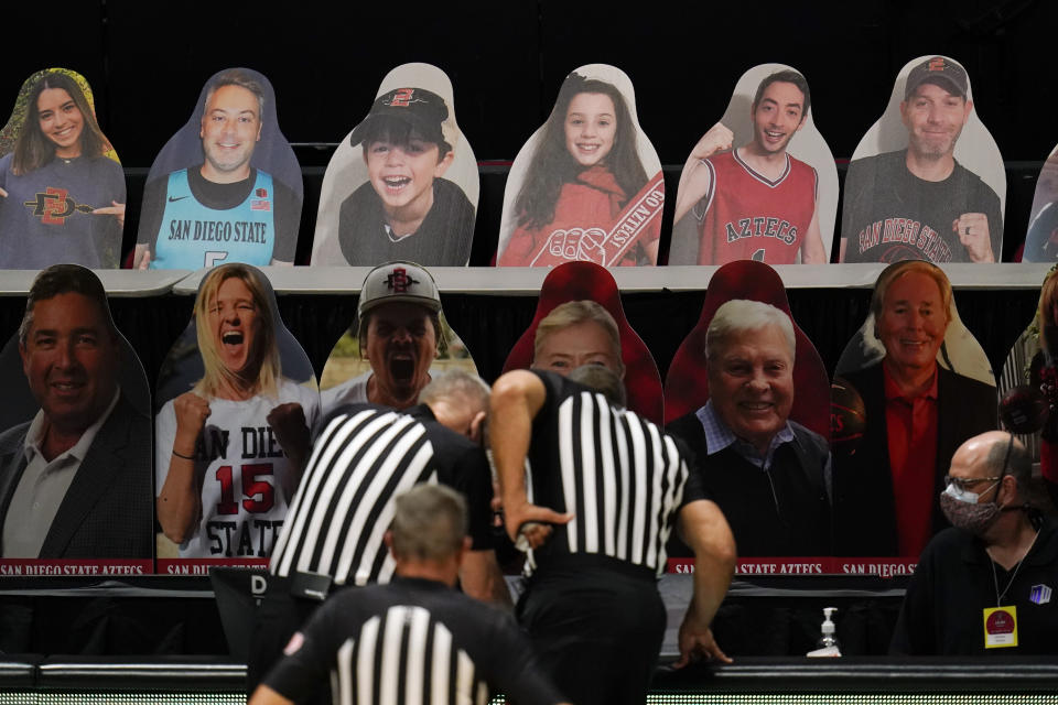 Cardboard cutouts of fans are displayed as officials determine how many seconds are left in the an NCAA college basketball game between boise State and San Diego State during the second half Thursday, Feb. 25, 2021, in San Diego. The game went into overtime. (AP Photo/Gregory Bull)