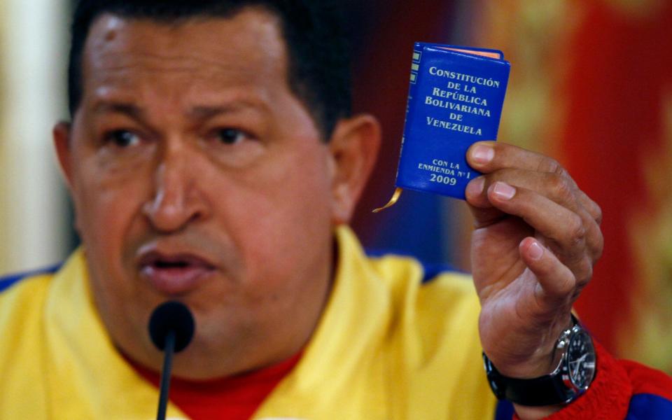 Venezuela's late president Hugo Chavez pictured in 2010 holding up a miniature copy of the constitution. - Credit: AP