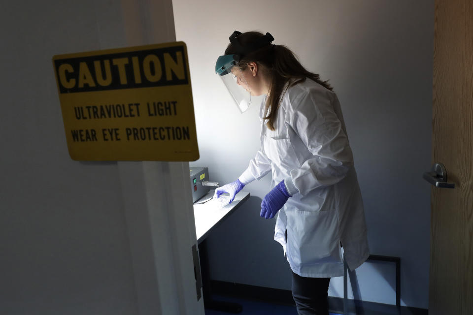 In this Wednesday, Jan. 15, 2020, photo, scientist and study director Jennifer Molignano places living human skin tissues under a solar simulator machine that emits ultraviolet B rays, while demonstrating an experiment created to simulate the exposure of human skin tissue to sunlight, at a MatTek Corporation lab, in Ashland, Mass. MatTek is a tissue engineering company that performs non-animal testing on cosmetics, skin care products and pharmaceuticals. (AP Photo/Steven Senne)