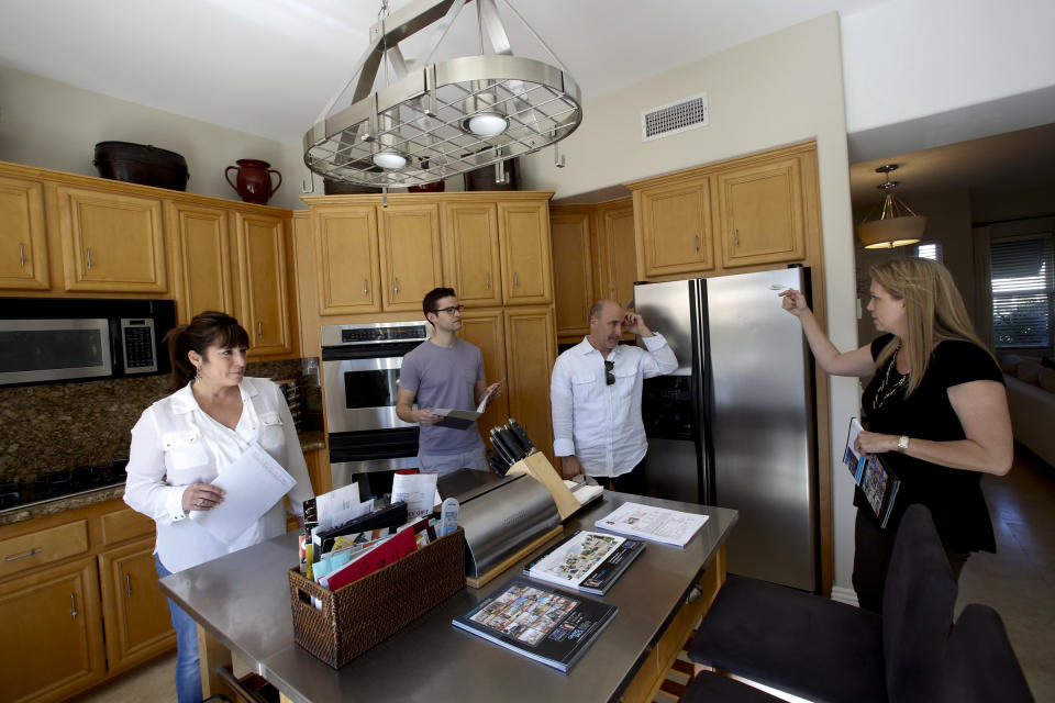 Real estate agent Tracey Becker, right shows the kitchen to Cindy Festa (CQ), left, Chris Reekie (CQ), second from left, and Ken Rota (CQ), second from right as potential buyers look at a home at Venice, California during an open house. (Credit: Anne Cusack/Los Angeles Times via Getty Images)