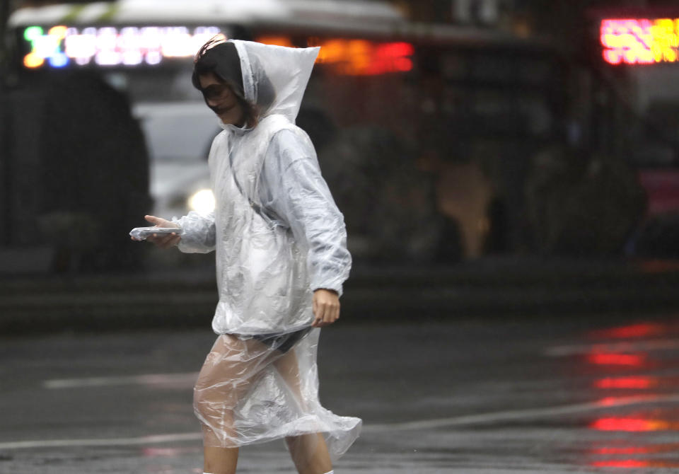 A woman walks in the rain as Typhoon Koinu approaches to Taiwan in Taipei, Taiwan, Wednesday, Oct. 4, 2023. (AP Photo/Chiang Ying-ying)