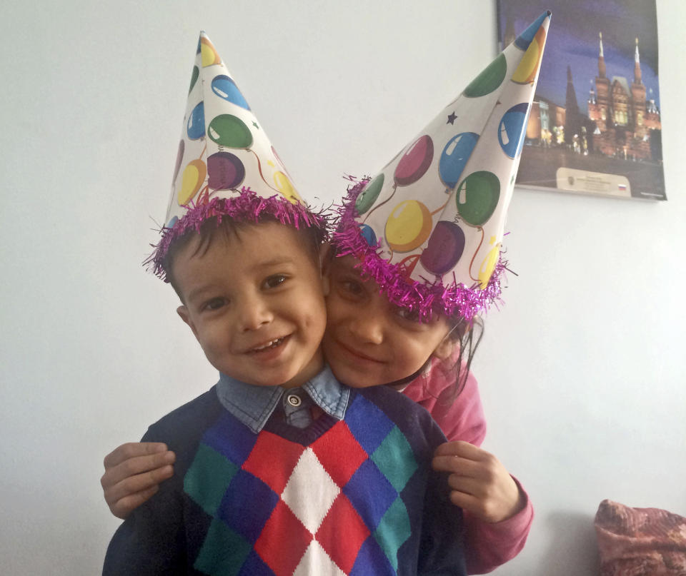 In this photo taken on Friday, Jan. 3, 2014, Abuzar Ahmad, left, the only surviving child of Agence France-Presse journalist Sardar Ahmad, who was killed with the rest of his family in an attack on a Kabul hotel, and his sister Nilofar pose for a picture during a birthday party in Kabul, Afghanistan. Family members say the nearly 2-year-old son of the much loved Afghan journalist has emerged from a coma and his condition is improving. The news comes as hundreds of dignitaries, colleagues and loved ones gathered in a memorial service for Ahmad, his wife and two children who were killed in the attack. Relatives say the toddler Abuzar was shot five times when gunmen began shooting diners in a restaurant at the Serena hotel. His father, mother, brother and sister were all killed and relatives called it a miracle that he survived. (AP Photo/Turaj Rais)