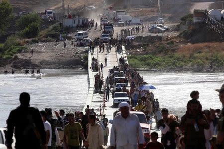 FILE PHOTO: Displaced people from the minority Yazidi sect, fleeing the violence in the Iraqi town of Sinjar, re-enter Iraq from Syria at the Iraqi-Syrian border crossing in Fishkhabour, Dohuk province, August 10, 2014. REUTERS/Ari Jalal/File photo