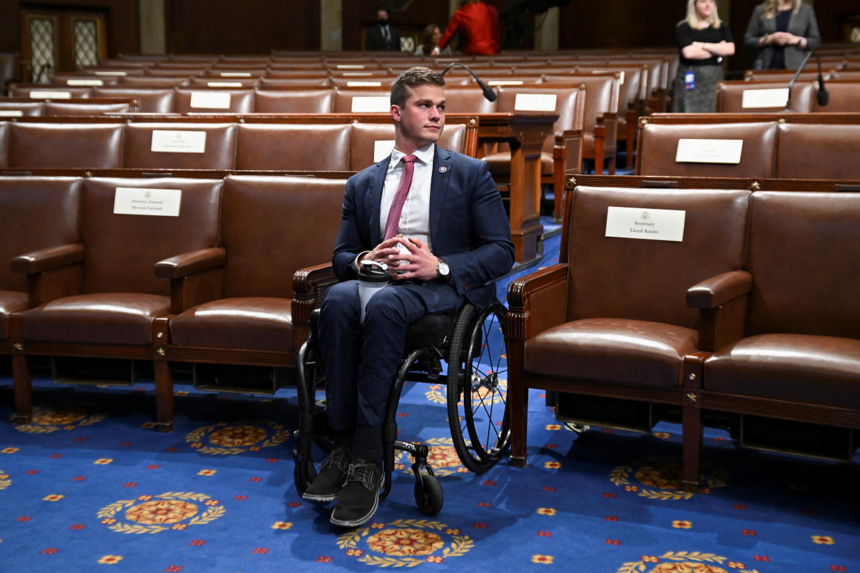 Rep. Madison Cawthorn seated in his wheelchair amid empty seats in the House Chamber.