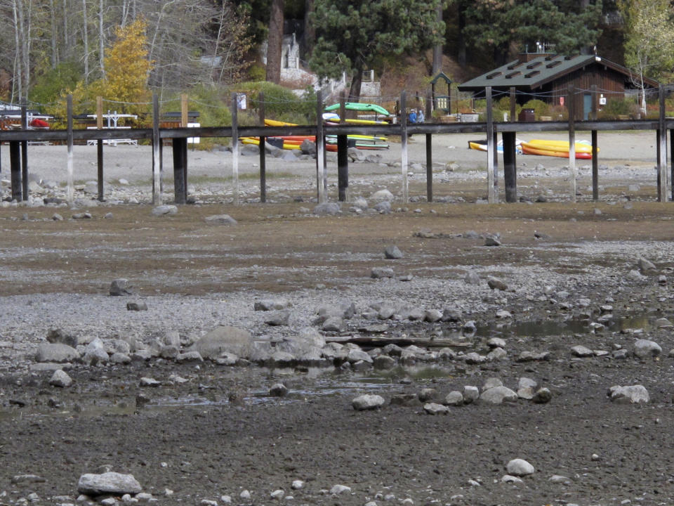 Kayaks and rafts are stacked along Lake Tahoe's receding shoreline Wednesday, Oct. 20, 2021 at Tahoe City, Calif. Drought fueled by climate change has dropped Lake Tahoe below its natural rim and halted flows into the Truckee River, an historically cyclical event that's occurring sooner and more often than it used to raising fears about what might be in store for the famed alpine lake. (AP Photo/Scott Sonner).