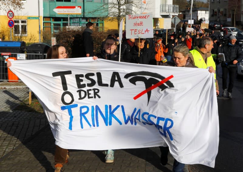 Demonstrators hold anti-Tesla posters during a protest against plans by U.S. electric vehicle pioneer Tesla to build its first European factory and design center near Berli