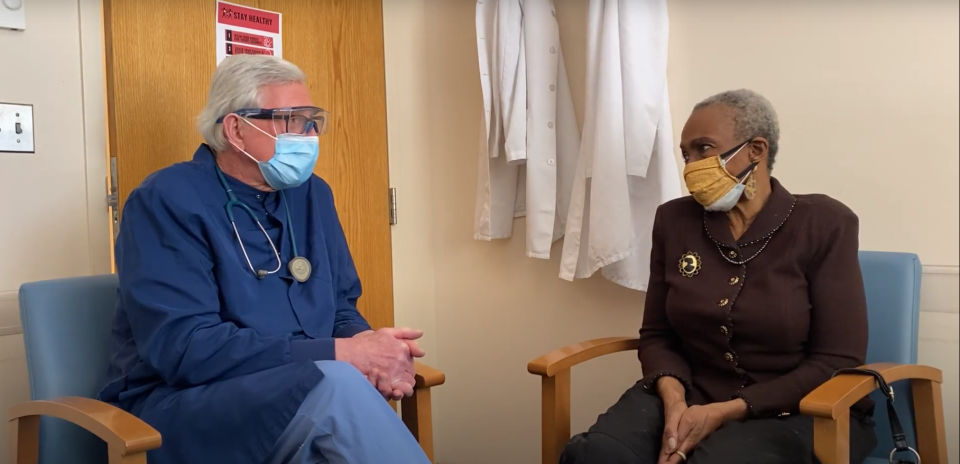 Jewelean Jackson, right, a patient at Community-University Health Care Center in Minnesota, chats with Dr. Chris Reif about the COVID-19 vaccine.