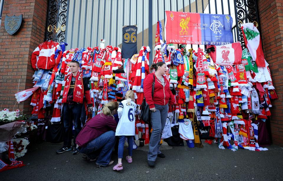 A fan ties a scarf to the Shankly Gates at Anfield, Liverpool, England, before the Hillsborough 25th Anniversary Memorial Service, Tuesday April 15, 2014. About 30,000 people, including Liverpool players past and present, are expected to attend a memorial service at Anfield marking the 25th anniversary of the Hillsborough Stadium disaster that killed 96 Liverpool fans. Brendan Rodgers and Roberto Martinez, the managers of Liverpool and Everton, will deliver readings as Merseyside unites to remember those who died in Britain’s worst sports tragedy. (AP Photo/PA, Martin Rickett) UNITED KINGDOM OUT NO SALES NO ARCHIVE