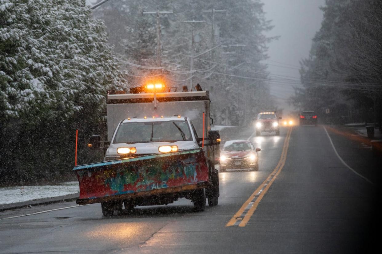 A snow plow rolls through the streets of Surrey, B.C., after several centimetres of snow fell on Metro Vancouver on Monday morning. (Ben Nelms/CBC - image credit)