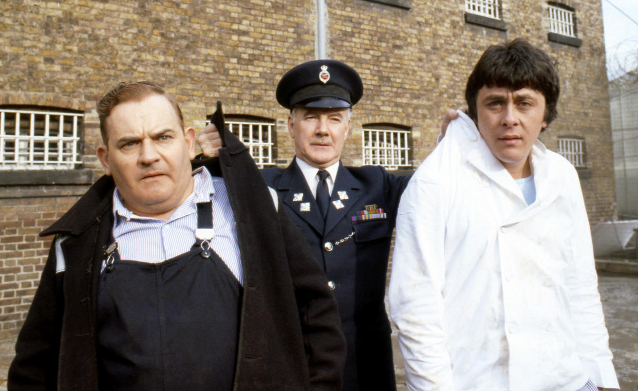 Old lag Fletcher (Ronnie Barker), fellow prisoner Godber (Richard Beckinsale) and prison officer Mackay (Fulton Mackay) during location shooting for the film version of their TV series "Porridge" at Chelmsford Jail, which has been empty since a fire last year.   (Photo by PA Images via Getty Images)