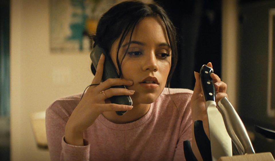 Jenna Ortega as Tara holding a knife while talking on the phone in "Scream 5"