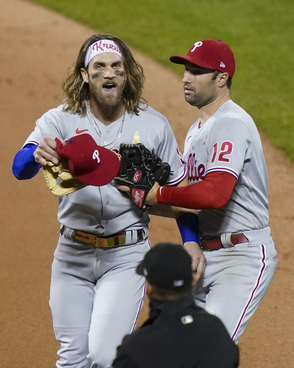 Philadelphia Phillies' Bryce Harper, left, reacts next to Neil Walker (12) after umpire Roberto Ortiz, below, threw him out of the team's baseball game against the New York Mets during the fifth inning Saturday, Sept. 5, 2020, in New York. (AP Photo/John Minchillo)