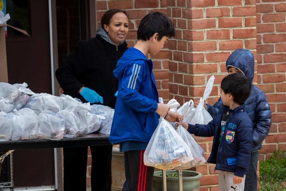 Children collect their free meal at East Silver Spring Elementary School, Tuesday, March 24, 2020, in Silver Spring, Md, provided by the Montgomery (Md) County Public School to school children for the duration of the state-mandated coronavirus pandemic emergency school closure. The Monday to Friday food distribution which includes breakfast, lunch and dinner has been expanded to include weekends in collaboration with Manna Food Center, many restaurants, nonprofit partners, PTAs and other organizations who have stepped up and are providing meals, groceries and gift cards to families in need. (AP Photo/Manuel Balce Ceneta)