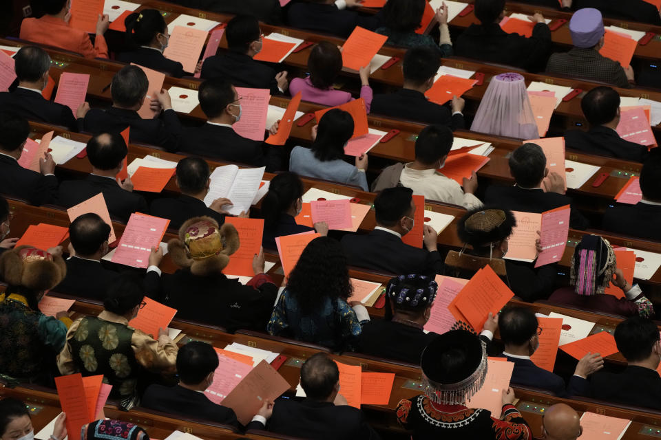 Delegates hold voting papers as they prepare to elect state leaders during a session of China's National People's Congress (NPC) at the Great Hall of the People in Beijing, Friday, March 10, 2023. (AP Photo/Mark Schiefelbein)