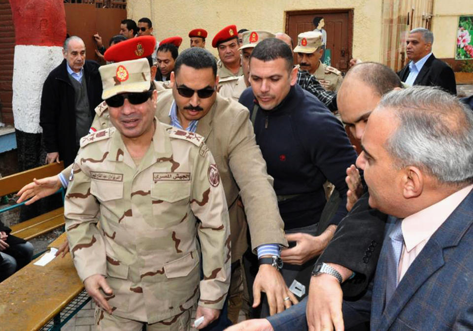 FILE - In this Tuesday, Jan. 14, 2014 file photo released by the Egyptian Defense Ministry, Defense Minister Gen. Abdel-Fattah el-Sissi, left, visits a polling site in the Heliopolis neighborhood of Cairo, Egypt, on the first day of voting in the constitutional referendum. Egypt’s state TV said Monday, Jan. 27, 2014 that the country’s Interim President issued a presidential decision, promoting the powerful army chief who led the July coup removed Islamist president from power, to the top military rank of marshal. (AP Photo/Egyptian Defense Ministry via Facebook, File)