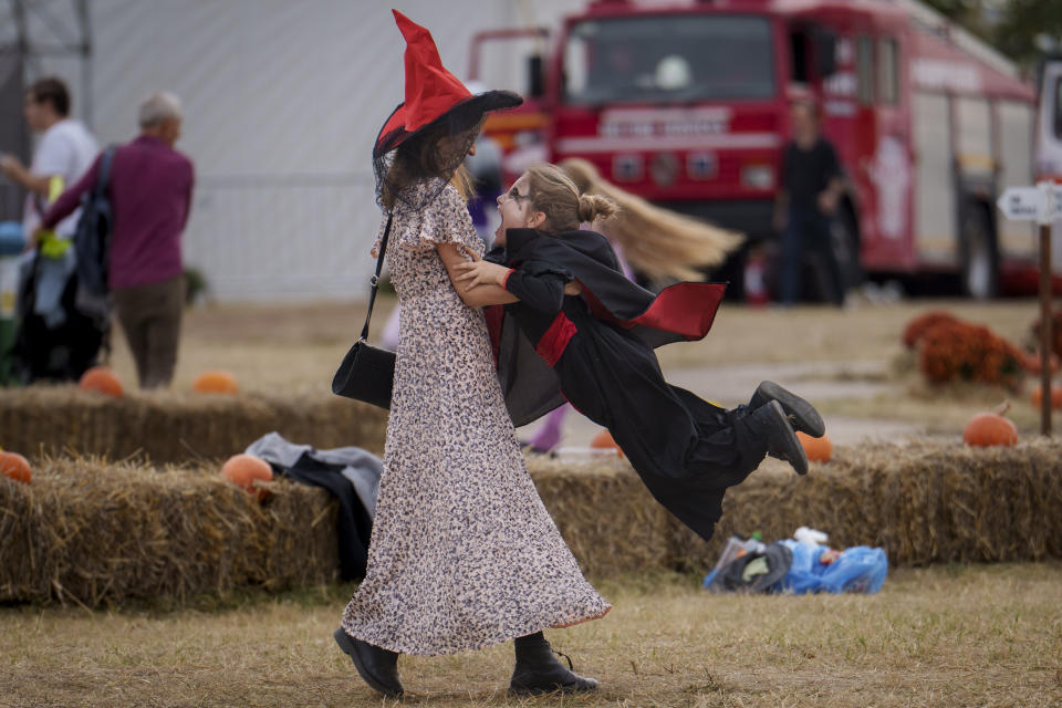 A woman plays with a child at the West Side Hallo Fest, a Halloween festival in Bucharest, Romania, Friday, Oct. 27, 2023. Tens of thousands streamed last weekend to Bucharest's Angels' Island peninsula for what was the biggest Halloween festival in the Eastern European nation since the fall of Communism. (AP Photo/Vadim Ghirda)
