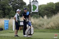 Matt Wallace, right, of England, stands with his caddie David McNeilly before teeing off on the third hole during the second round of the Travelers Championship golf tournament at TPC River Highlands, Friday, June 26, 2020, in Cromwell, Conn. Wallace is playing the second round by himself after two other golfers in his group, Denny McCarthy and Bud Cauley, withdrew from the tournament. McCarthy told Golfchannel.com that he withdrew from the tournament after feeling sick Thursday night and testing positive for the coronavirus on Friday. Cauley, who played with McCarthy on Thursday, also withdrew before Friday's second round. McCarthy became the third PGA Tour player to test positive for the virus since its restart and the second this week, joining Cameron Champ who withdrew on Tuesday. Nick Watney withdrew just before the second round of last week's RBC Heritage Championship. (AP Photo/Frank Franklin II)