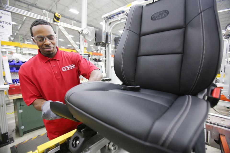 At Magna International, a seat manufacturing company, Stevan Ware, 21, of Detroit repairs Durango Overland seats.