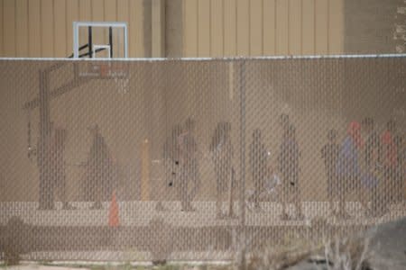 Migrant boys spend time in a recreation area outside Casa Padre, an immigrant shelter for unaccompanied minors, in Brownsville, Texas. REUTERS/Loren Elliott