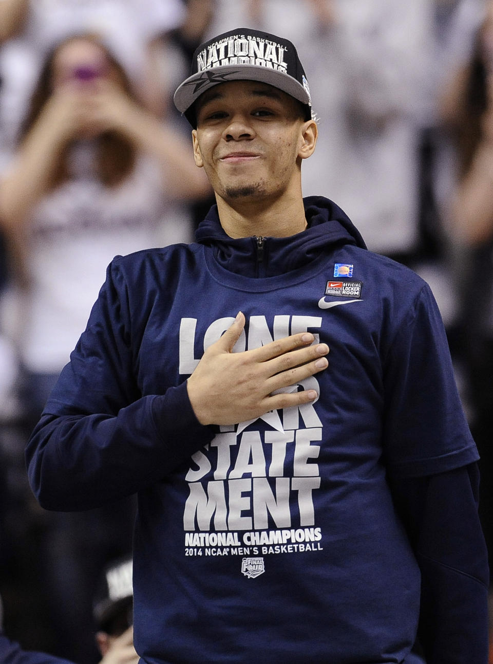 Connecticut's Shabazz Napier places his hand over his heart as he is cheered on by fans at a pep rally celebrating the program's fourth national championship, Tuesday, April 8, 2014, in Storrs, Conn. (AP Photo/Jessica Hill)