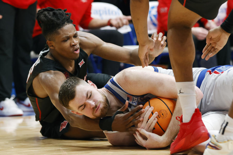 Kansas center Hunter Dickinson, bottom, gets control of the ball as Houston forward Joseph Tugler, top, defends during the second half of an NCAA college basketball game, Saturday, Feb. 3, 2024, in Lawrence, Kan. (AP Photo/Colin E. Braley)