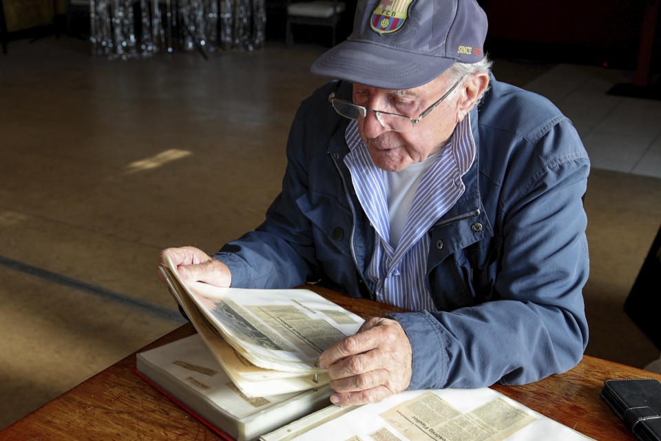 Makkabi Berlin co-founder Marian Wajselfisz looks at old newspaper clippings during an interview with The Associated Press, in Berlin, Wednesday, July 26, 2023. When Makkabi Berlin takes the field on Sunday Aug. 13, 2023, the soccer club founded by Holocaust survivors will become the first Jewish team to play in the German Cup. (AP Photo/Ciaran Fahey)