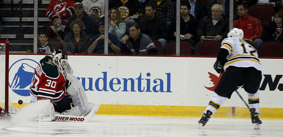 A shot by Boston Bruins right wing Jarome Iginla (12) gets pass New Jersey Devils goalie Martin Brodeur (30) for a goal during the second period of an NHL hockey game, Tuesday, March 18, 2014, in Newark, N.J. (AP Photo/Julio Cortez)