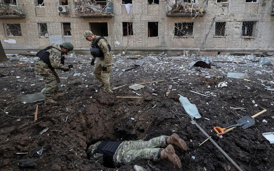 Kharkiv police work at the site where buildings were damaged by a Russian military strike