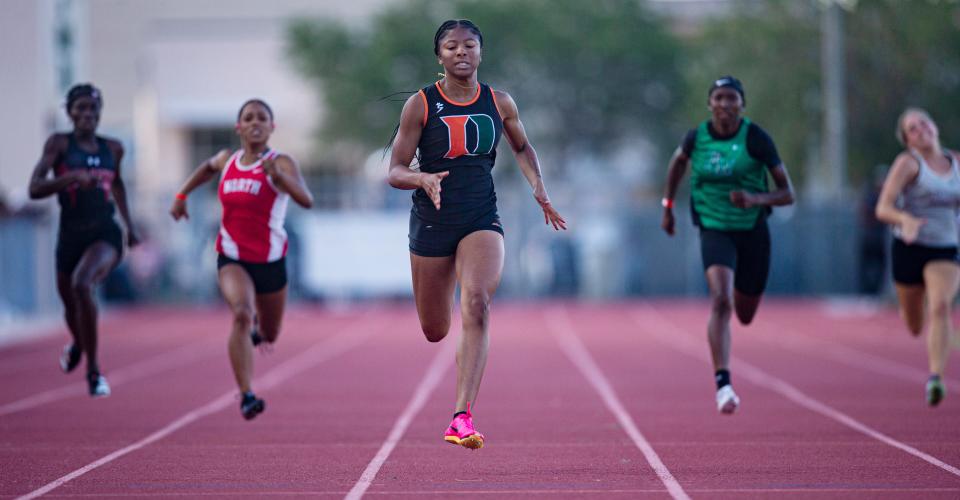 Kayla Hopkins, center,  from Dunbar wins the 200 meters during the FHSAA 3A District 11 track & field meet at Dunbar High School on April 20, 2023.   