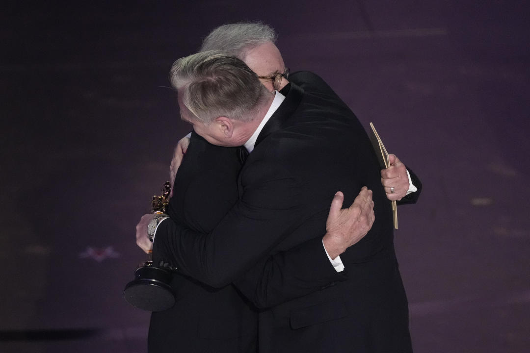 Steven Spielberg, left, embraces Christopher Nolan as he accepts the award for best director for 