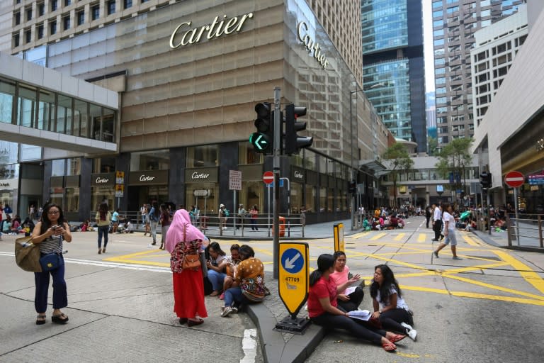 The city's army of domestic helpers sit in parks or on pavements, bridges and walkways on their one mandatory day off