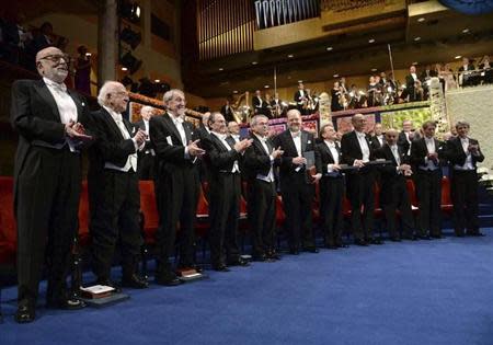 Nobel prize laureates (front L-R) Francois Englert and Peter Higgs in Physics; Martin Karplus, Michael Levitt and Arieh Warshel in Chemistry; James Rothman, Randy Schekman, Thomas Sudhof in Medicine; Eugene Fama, Lars Peter Hansen and Robert J.Shiller in Economics, applaud during the 2013 Nobel Prize award ceremony in Stockholm December 10, 2013. REUTERS/Fredrik Sandberg/TT News Agency