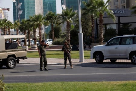 Kurdish security members stand guard near a restaurant where Turkish diplomats and Turkish consulate employee were killed in Erbil