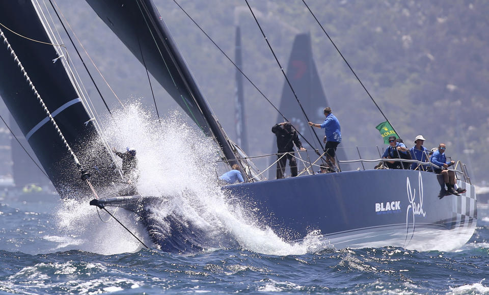 The bowman of Blackjack is sprayed with water as the yacht heads the field during the start of the Sydney Hobart yacht race in Sydney, Wednesday, Dec. 26, 2018. The 630-nautical mile race has 85 yachts starting in the trip to the island state of Tasmania. (AP Photo/Rick Rycroft)