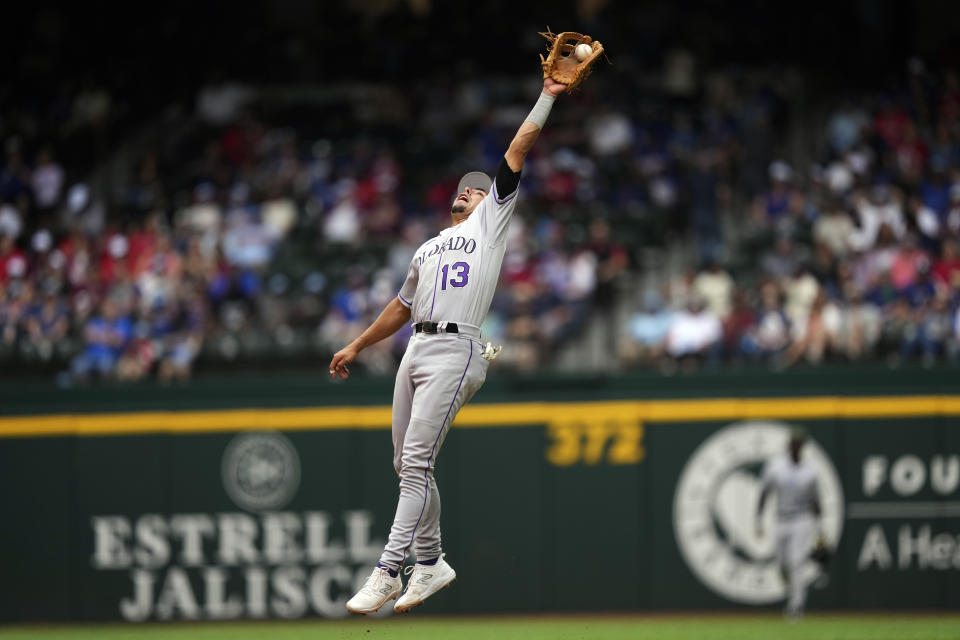 Colorado Rockies second baseman Alan Trejo (13) catches a line out against Texas Rangers' Leody Taveras during the seventh inning of a baseball game in Arlington, Texas, Sunday, May 21, 2023. (AP Photo/LM Otero)