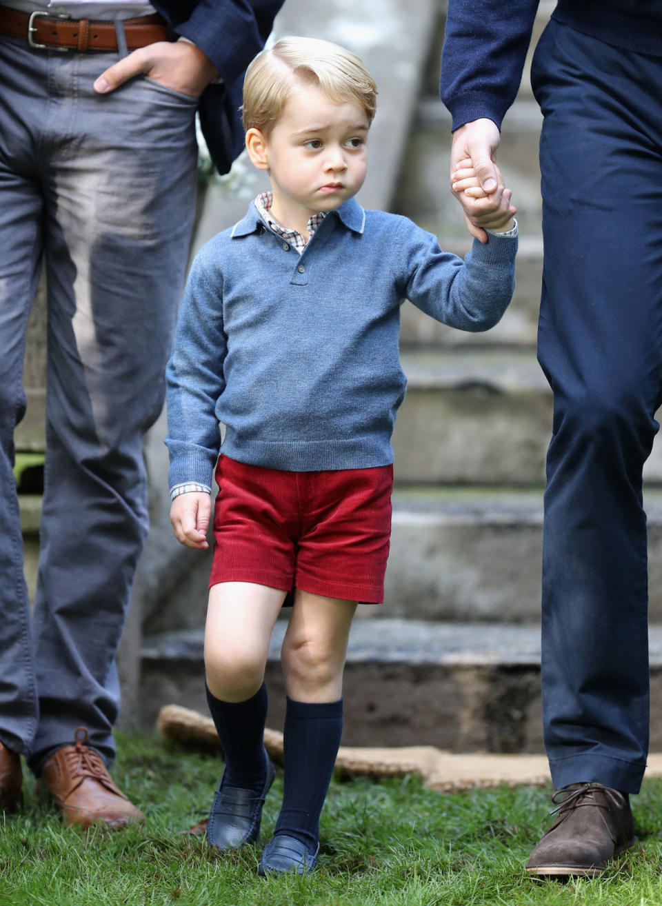 Prince George wears a $84 blue sweater as he holds his father's hand. (Photo: Getty Images)