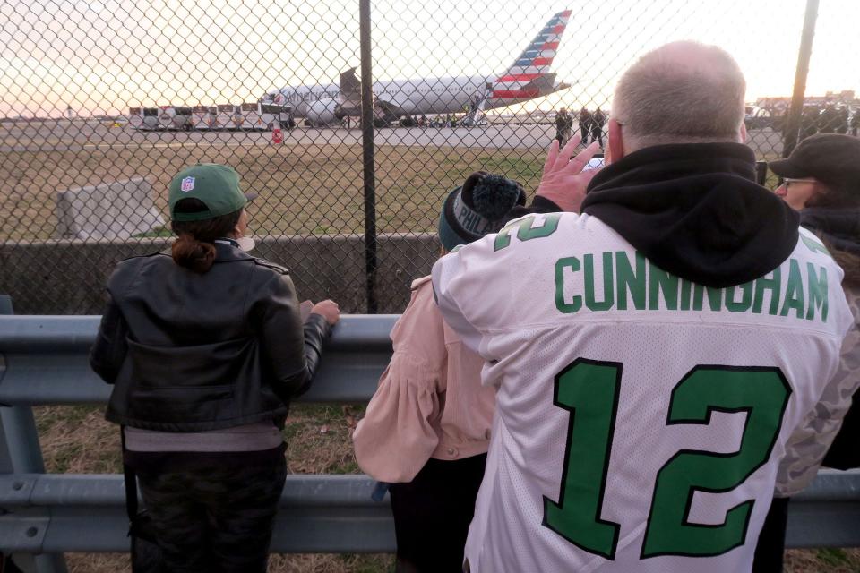 Eagles fans line a fence along Island Avenue after the team's flight landed at Philadelphia International Airport late Monday afternoon, February 13, 2023.  The Eagles were defeated by the Kansas City Chiefs in Super Bowl LVII the previous night.