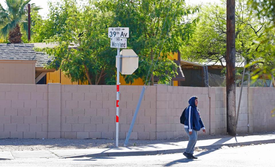 A pedestrian walks past the intersection near where a 10-year-old girl was shot and killed after an unexpected incident possibly involving road rage in Phoenix, Ariz., on April 3, 2019.