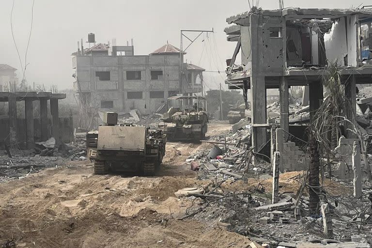En esta imagen sin fecha distribuida por el ejército israelí, vehículos blindados de transporte de tropas avanzan entre edificios destruidos durante una operación terrestre en la Franja de Gaza, (Fuerzas de Defensa de Israel vía AP)